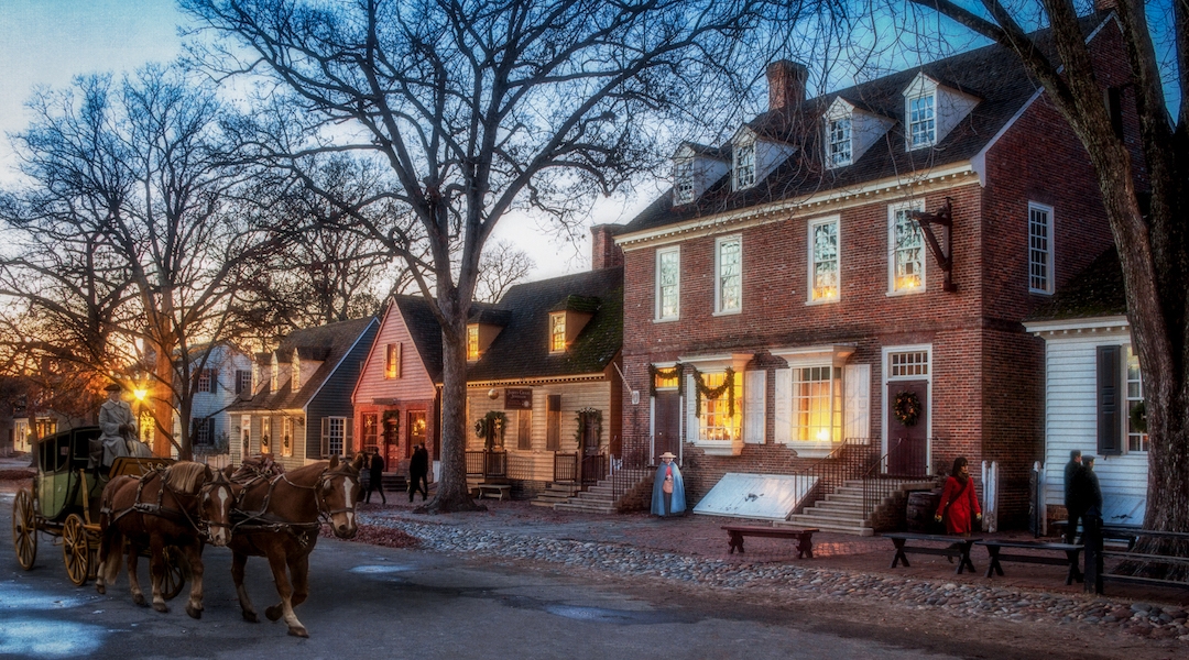 A horse-drawn carriage down a quiet historic colonial-era street