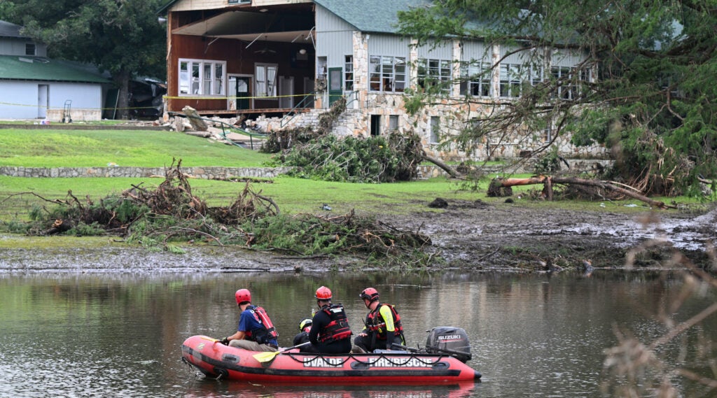 A search and rescue team looks for people along the Guadalupe River near a damaged building at Camp Mystic in Hunt, Texas, on July 7, 2025, following severe flash flooding that occurred during the July 4 holiday weekend.