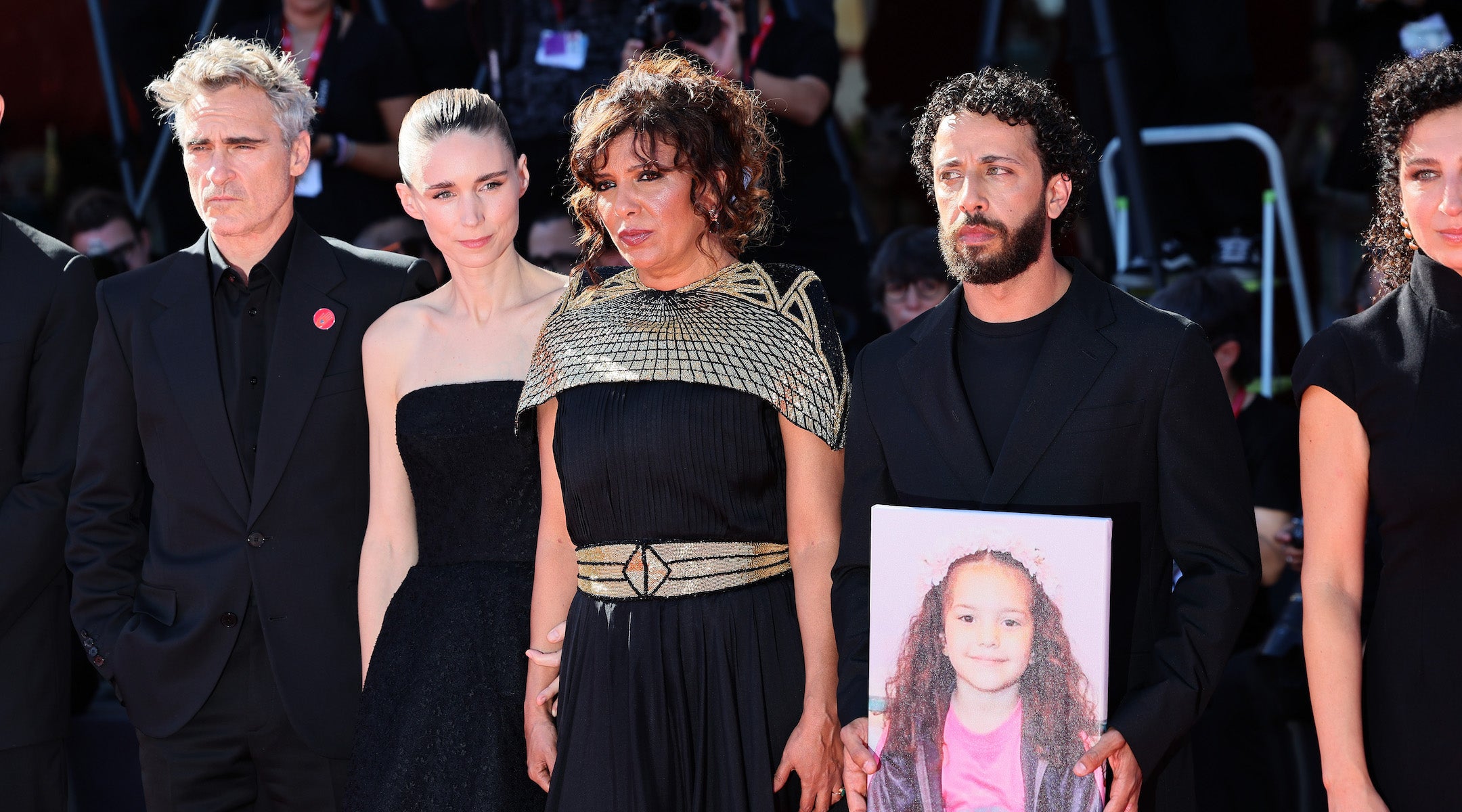 Filmmakers hold a photo of Hind Rajab at a red-carpet premiere