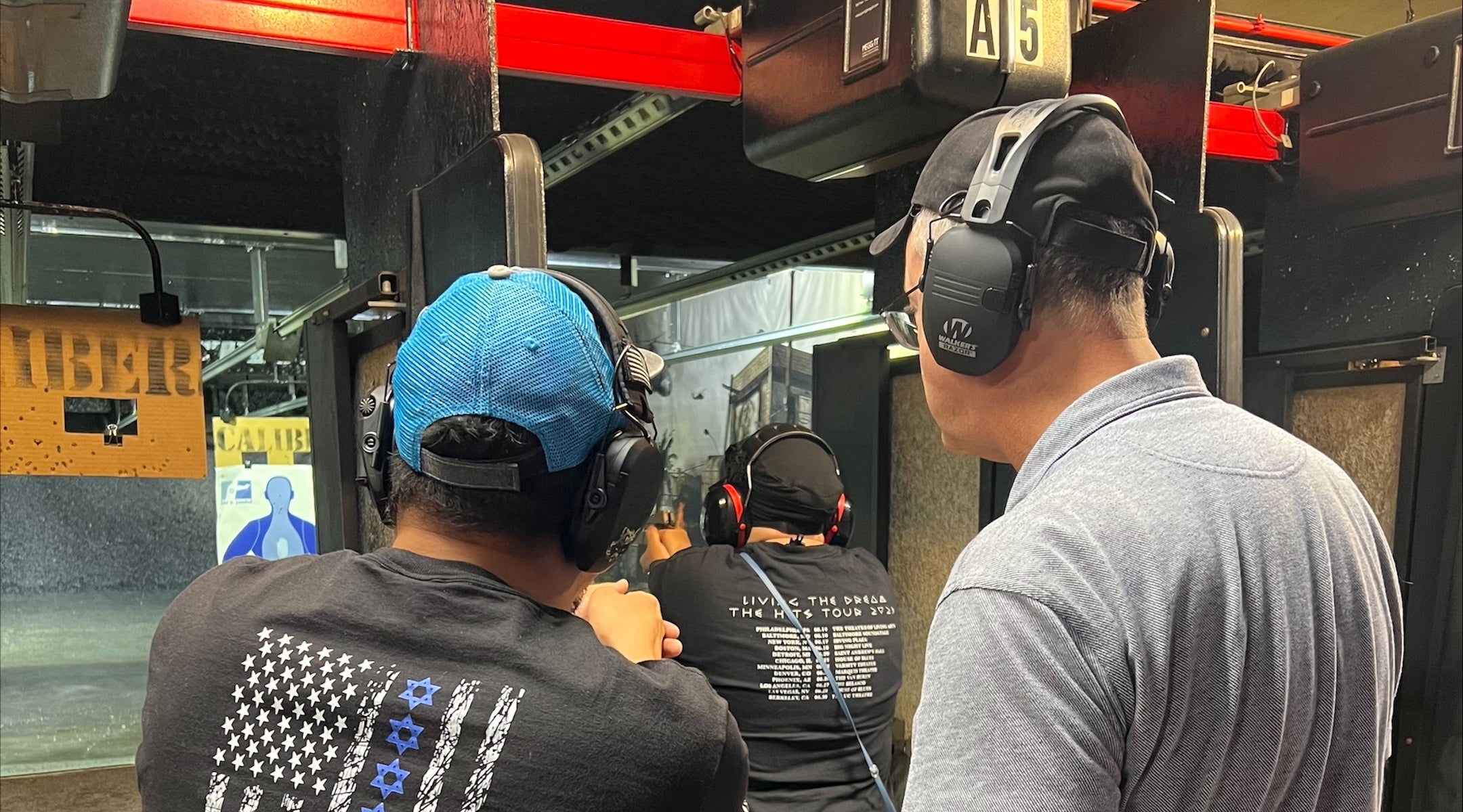 A photo of three people facing away at a shooting range.